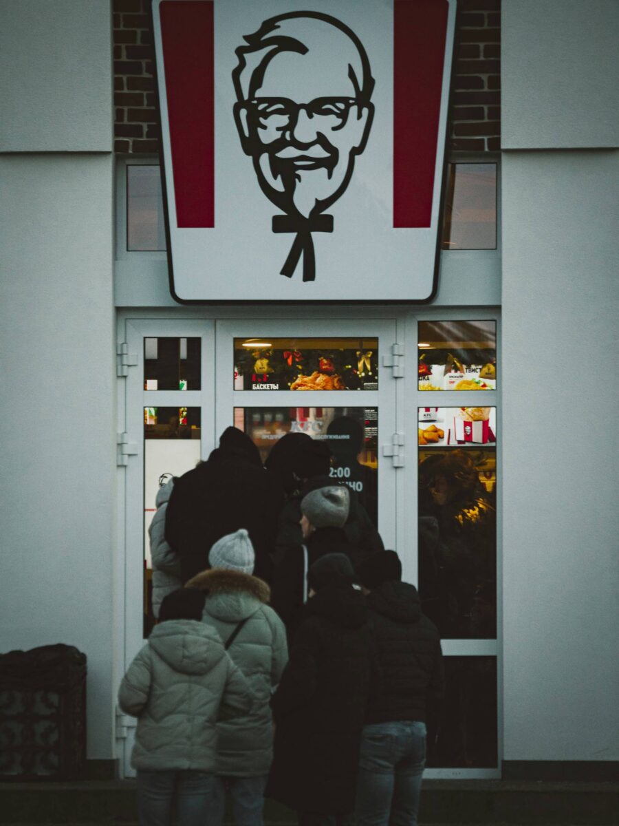 Imagen con personas entrando a un restaurante KFC