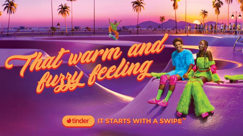 Imagen de la campaña de Tinder "It starts with a swipe" con dos personas sentadas en el suelo.