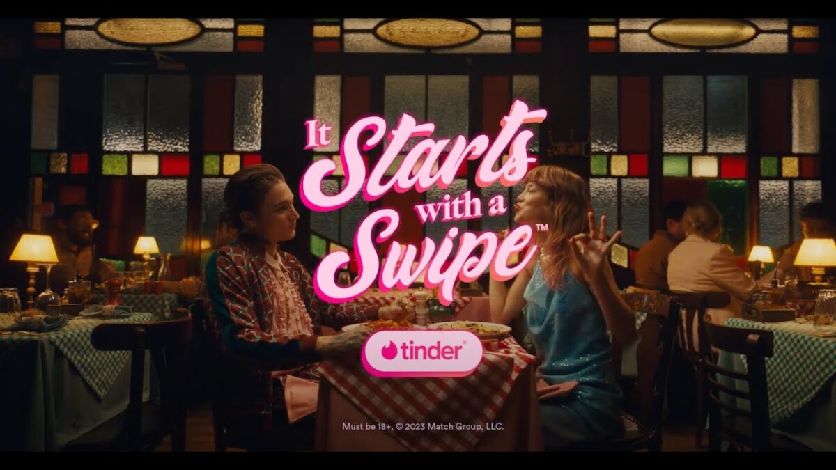 Imagen de la campaña de Tinder "It starts with a swipe" con dos personas cenando en un restaurante