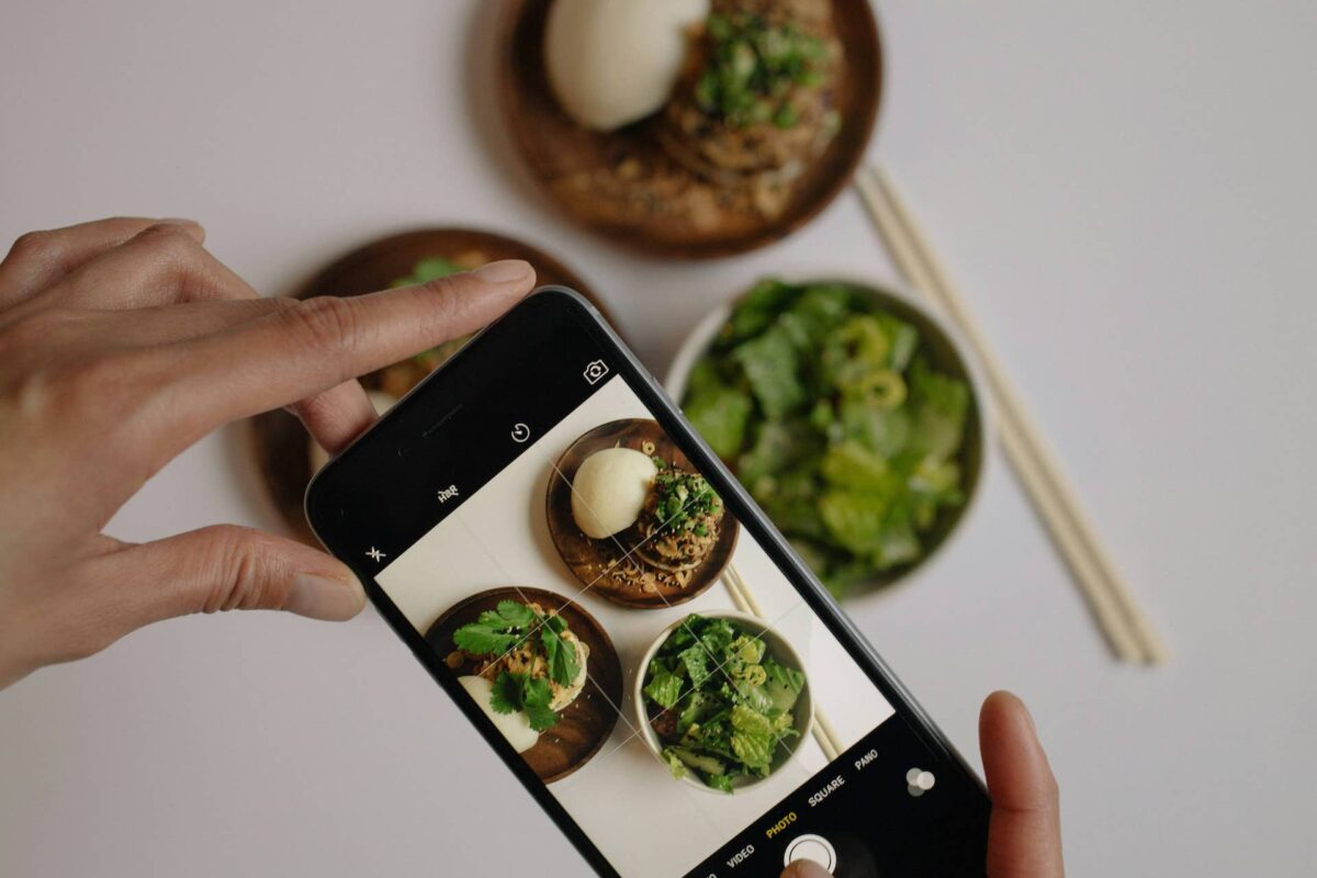 Imagen de un móvil haciendo una foto a un plato de comida.